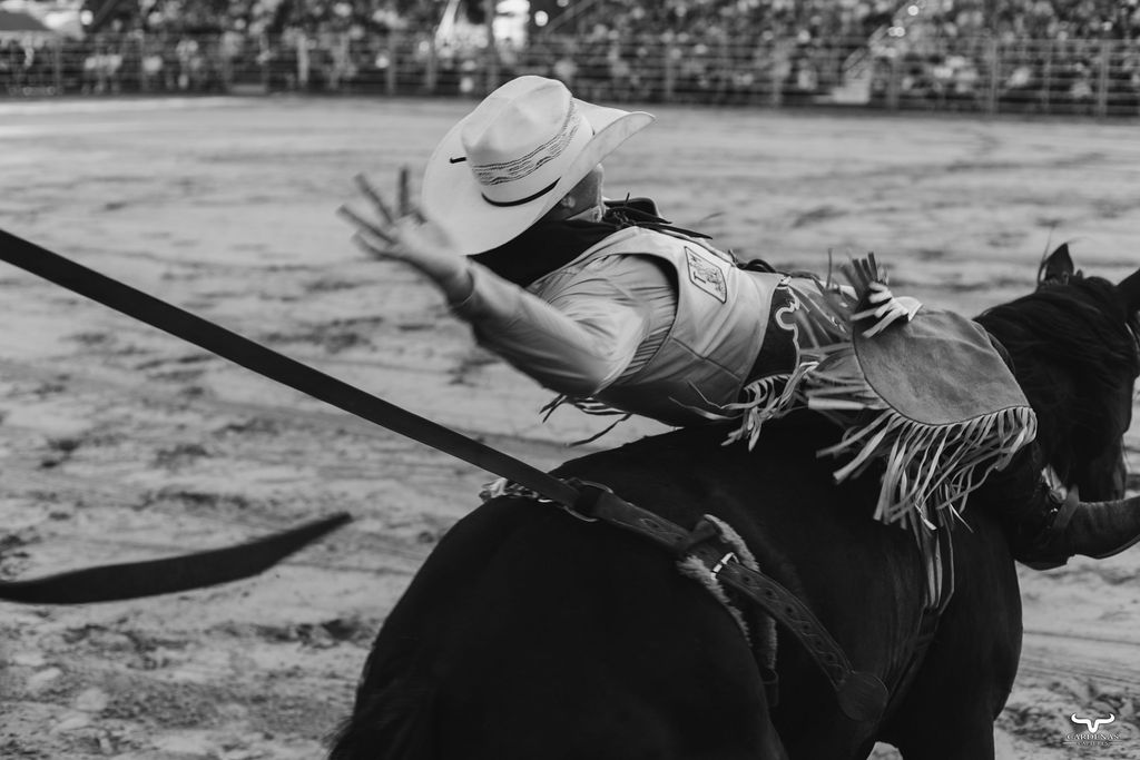 Bronc rider mid-ride in black and white